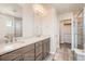 Well-lit bathroom features double sinks, granite countertops, modern fixtures, and a glass-enclosed shower at 2387 Bristol St, Superior, CO 80027