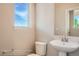 Powder room featuring a pedestal sink, modern fixtures, and a sunlit window at 2387 Bristol St, Superior, CO 80027