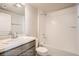 Bathroom features a tub with a shower, neutral-toned walls and tiles, with a sink and a white toilet at 2387 Bristol St, Superior, CO 80027