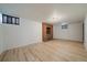 Spacious basement featuring light wood flooring and a brick fireplace adding to its warmth at 1018 Kelly Pl, Longmont, CO 80501