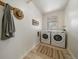 Neat laundry room with side-by-side washer and dryer, accented by a rug and wall decor at 1018 Kelly Pl, Longmont, CO 80501