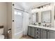 Bathroom with dual sinks, marble countertops, modern fixtures, and shower-tub combo at 4241 Brookwood Pl, Highlands Ranch, CO 80130