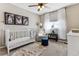 Bright Bedroom with neutral decor features a white crib, glider chair, and whimsical artwork at 4241 Brookwood Pl, Highlands Ranch, CO 80130