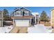 Two-story home with blue siding, attached two-car garage, and snow-covered front yard at 4241 Brookwood Pl, Highlands Ranch, CO 80130