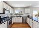 Bright kitchen with white cabinets, black countertops, stainless steel appliances, and hardwood floors at 4241 Brookwood Pl, Highlands Ranch, CO 80130