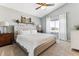 Spacious main bedroom offers a tufted headboard, ceiling fan, and a sunlit window at 4241 Brookwood Pl, Highlands Ranch, CO 80130