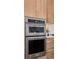 Close-up of stainless steel double oven and microwave, set within a warm wood cabinet, adding a modern touch at 81 Simmental Loop, Castle Rock, CO 80104