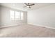 Spacious bedroom featuring neutral carpet, a ceiling fan, and three sunny windows at 21127 E 62Nd Dr, Aurora, CO 80019