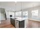 Open-concept kitchen with quartz countertops and a kitchen island overlooking the living room at 21127 E 62Nd Dr, Aurora, CO 80019