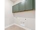 Convenient laundry room featuring green cabinets and a tile floor at 21127 E 62Nd Dr, Aurora, CO 80019