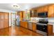 Well-lit kitchen features wooden cabinets, stainless steel appliances, and adjacent laundry room for added convenience at 9633 Fox Valley Dr, Morrison, CO 80465