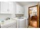 Functional laundry room boasts a sink, white cabinets, and modern washer/dryer units at 9633 Fox Valley Dr, Morrison, CO 80465