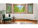 A well-lit living room shows large windows with tree views and cozy seating at 9633 Fox Valley Dr, Morrison, CO 80465