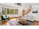 A bright living room features hardwood floors, large windows, and a comfortable seating area at 9633 Fox Valley Dr, Morrison, CO 80465