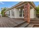 Wooden back deck with a brick support column leading to the house with multiple windows and glass doors at 13844 E Lehigh Ave # H, Aurora, CO 80014