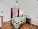 Bedroom featuring hardwood floors, ceiling fan, bedside lamps, and window at 13844 E Lehigh Ave # H, Aurora, CO 80014