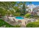 Inviting community pool featuring lounge chairs and tables surrounded by lush greenery and mature trees at 13844 E Lehigh Ave # H, Aurora, CO 80014