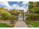 Community pool featuring a gated entrance, lush landscaping, and refreshing blue water under a partly cloudy sky at 13844 E Lehigh Ave # H, Aurora, CO 80014