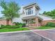 Exterior building with a red brick foundation, white siding, large windows, and a brick walkway to the front door at 13844 E Lehigh Ave # H, Aurora, CO 80014
