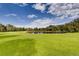 Scenic pond surrounded by lush green grass and mature trees under a partly cloudy sky at 13844 E Lehigh Ave # H, Aurora, CO 80014