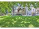 Lush backyard featuring mature trees offering shade, well-maintained lawn, and patio at 1607 Garnet St, Broomfield, CO 80020