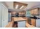 Bright kitchen features stainless steel appliances, hardwood floors, island with breakfast bar, and granite countertops at 1607 Garnet St, Broomfield, CO 80020
