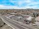 Overhead view of a commercial district with various stores, parking lots, and streets lined with residential areas at 677 Vrain St # 10, Denver, CO 80204