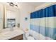 Bright bathroom with a single sink vanity and a blue and white striped shower curtain at 1282 Eldorado Dr, Superior, CO 80027