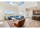 Open living room with soaring ceiling, large windows and hardwood floors flows into the kitchen with island seating at 1282 Eldorado Dr, Superior, CO 80027
