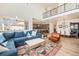 Bright living room features a soaring ceiling, large windows, hardwood floors, and an open concept layout to kitchen and dining room at 1282 Eldorado Dr, Superior, CO 80027