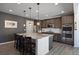 Modern kitchen with granite island, stainless steel appliances, and dark wood cabinets at 6211 Leilani Ln, Castle Rock, CO 80108