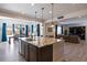 Large kitchen island with seating, a sink, and granite countertops, overlooking the living and dining areas at 6211 Leilani Ln, Castle Rock, CO 80108