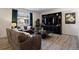 Spacious living room featuring leather sofas, a large TV, and wood-look flooring at 6211 Leilani Ln, Castle Rock, CO 80108