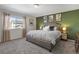 Main bedroom with large bed, green accent wall, and ample natural light at 6211 Leilani Ln, Castle Rock, CO 80108