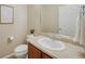 Well-lit half bathroom with a wooden vanity, neutral walls, and a modern mirror at 12340 Syracuse St, Thornton, CO 80602