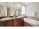 Bathroom with dual sinks, granite countertop, soaking tub and step-in shower at 12340 Syracuse St, Thornton, CO 80602