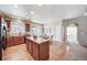 Bright kitchen with wooden cabinets, island, hardwood floors, and an adjacent dining area at 12340 Syracuse St, Thornton, CO 80602