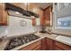 Kitchen features modern gas range and stainless steel vent hood, creating a chef-friendly space for culinary creations at 12340 Syracuse St, Thornton, CO 80602