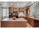 Well-lit kitchen featuring wood cabinets, an island, and modern appliances that create a functional cooking space at 12340 Syracuse St, Thornton, CO 80602