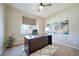 Home office with large window, desk, ceiling fan, and neutral decor at 12340 Syracuse St, Thornton, CO 80602
