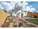 Spacious backyard with a stone patio, grassy area, lush landscaping, and water feature at 4883 Perry St, Denver, CO 80212