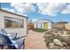 Landscaped backyard with a stone patio, garden bed, white garage, and seating at 4883 Perry St, Denver, CO 80212