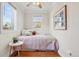 Cozy bedroom with natural light, hardwood floors, and a comfortable bed with accent pillows at 4883 Perry St, Denver, CO 80212