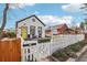 Charming white home with black trim, a bright yellow door, and a well-manicured front yard at 4883 Perry St, Denver, CO 80212
