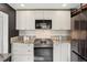 Modern kitchen with white cabinets, stainless steel appliances, granite counters and decorative black and white flooring at 4883 Perry St, Denver, CO 80212