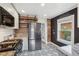 Bright kitchen showcasing stainless steel appliances, open shelving, modern flooring and contrasting black accent wall at 4883 Perry St, Denver, CO 80212
