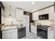 Modern kitchen with white cabinets, stainless steel appliances, granite counters and decorative black and white flooring at 4883 Perry St, Denver, CO 80212