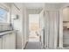 Bright laundry room with white cabinets, black countertops, patterned tile floor, and direct access to the sunroom at 4883 Perry St, Denver, CO 80212