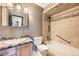 Neutral-toned bathroom showcasing a vanity with granite countertop, toilet, and tiled bathtub-shower combo at 2056 S Newark Way, Aurora, CO 80014