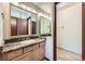 Bathroom with wood vanity, sink with granite counters, and a large mirror at 2056 S Newark Way, Aurora, CO 80014